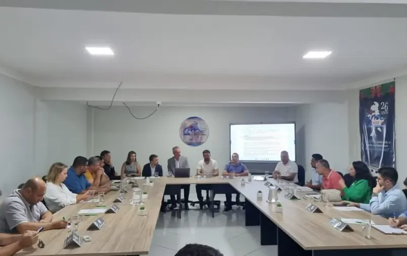 Equipe reunida com produtores e parceiros em mesa de trabalho